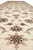 Low angle down the runner showing repeating palmettes, rosettes and light blue centers on cream
