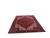 Angled full view of the red wool Heriz rug showing navy border and geometric field pattern