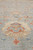 Close-up of a large ivory and coral palmette set against the pale blue field