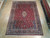 8'5" x 11'9" Persian Yazd rug laid flat on light wood showroom floor