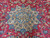 Close-up of ivory and blue 8 point star medallion on crimson vine scroll field