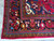 Corner detail with ivory fringe, camel guard stripe and turquoise zigzag minor border on wool rug