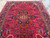 Large living room rug viewed lengthwise, symmetrical floral sprays radiating from the central medallion