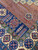 Close-up of the fine red lattice field beside the navy cypress and cross-medallion panel