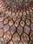 Close-up of gold, sage and pale blue lozenge panels radiating across the deep burgundy wool field