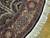 Maroon and beige outer border with rosette panels beside the ivory fringed circular edge