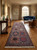 Rust and navy tribal runner laid on oak flooring in a traditional entry hall setting