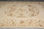 Round scrolling medallion and olive vine border photographed from the end of the ivory rug