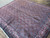 Angled view showing dense Herati lattice, ivory rose border and hand-knotted wool pile detail