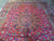 Overhead detail of the central medallion, pendant boteh and flowering vase motif on deep red ground