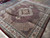 Hand-knotted Indian Mahi rug at an angle showing ivory main border and floral palmettes