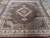Rectangular burgundy Oriental rug laid flat showing full medallion layout and ivory border
