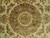 Close-up of the central medallion with salmon roses, green vine scrolls and gold ivory core