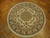 8x8 round Tabriz design rug displayed on herringbone parquet floor showing ivory field and fringe