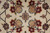 Gold and burgundy rosettes flanking a small green and pink rosette at the rug center