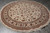 8x8 round Oriental rug laid flat on grey tile floor showing full ivory floral design