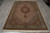 Full length view of the rust medallion Mahi rug with ivory fringe on grey plank flooring