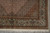 Corner detail with brown spandrel, sage border and multiple guard stripes framing the 7 by 10 rug