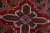 Close-up of blue and ivory star medallion with serrated leaf palmettes on rustic red wool