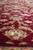 Floor-level angle across the wine red field showing lustrous silk highlights on floral sprays