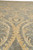 Detail of a cream rosette medallion surrounded by sweeping feathered leaves on gray ground