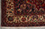 Corner detail with ivory main border, red guard stripe and rosette minor border above fringe