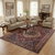 Burgundy and navy Bakhtiar area rug anchoring a neutral living room with hardwood floors and beige sofas