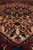Low angle detail of cream medallion field with brown vinework, blue rosettes and coral blossoms