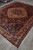 Vintage 1980s Persian village rug seen at an angle, showing overall medallion layout and wide border