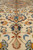 Wool pile detail of peach and navy palmette floating on ivory field near medallion