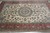 Angled floor view showing scrolling vinework and light blue medallion on cream wool pile