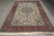 Hand-knotted Persian rug photographed lengthwise, coral border framing an ivory field with central floral medallion