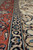 Coral main border and navy guard stripes seen up close on this 7x10 Persian rug