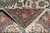 Folded corner revealing tight hand-knotted back, cotton foundation and ivory fringe of the rug