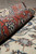 Rolled edge showing coral border depth and the plush wool with silk pile surface