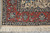 Corner detail with ivory fringe, coral palmette border and navy floral guard band