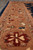 Detail of the camel-tan border with an 8 petal rust rosette and navy leaf accents