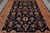 Large-scale palmettes and serrated leaves fill the navy blue ground of this hand-knotted Pakistani wool rug