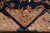 Folded corner revealing the cotton foundation, wool pile thickness and finely drawn tan border pattern