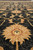 Macro of a golden 12 petal rosette glowing against the charcoal black wool field