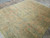 Angled view of the 8x10 Turkish rug showing low wool pile and geometric border bands