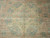 Central octagonal medallion detail in sage green and salmon from this vintage Oushak living room rug