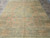 Overhead photo of the 7'9 x 9'10 wool area rug laid flat on travertine tile