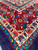 Ivory main border with red palmettes, turquoise guard stripe and cobalt flowers at the corner