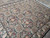 Angled floor view highlighting gold rosettes and rose blossoms across the dense black all-over field