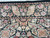 Close-up of the rose and carnation border with scalloped guard stripe and plush wool pile