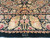 Woven signature cartouche in the end border below scrolling gold and rose flower garlands
