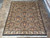 Living room size black wool rug laid flat on tile and viewed along its length
