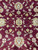 Close view of central rosette, curling vines and ivory blossoms woven in natural wool pile
