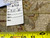 Back of the rug with hand-woven Oriental rug tag and tape measure showing knot density